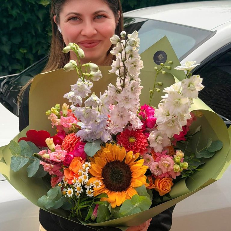 Ein üppiger Blumenstrauß mit Pfirsich- und weißen Rosen, Eukalyptus und zarten Akzenten.