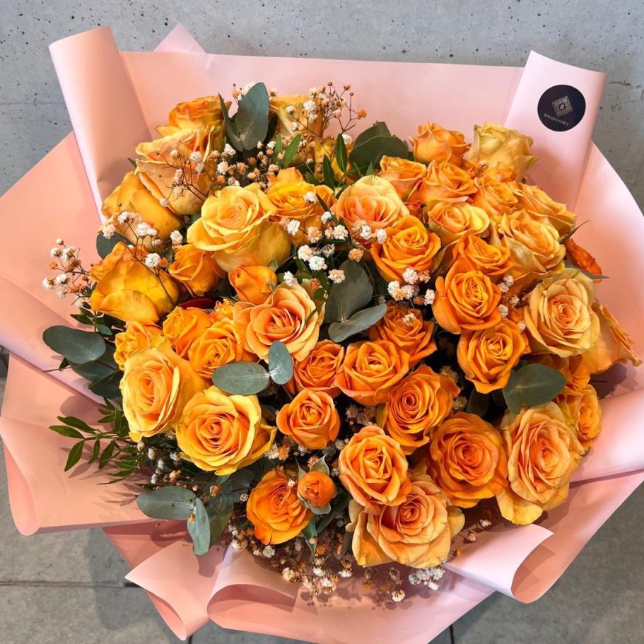 Ein üppiger Blumenstrauß mit Pfirsich- und weißen Rosen, Eukalyptus und zarten Akzenten.