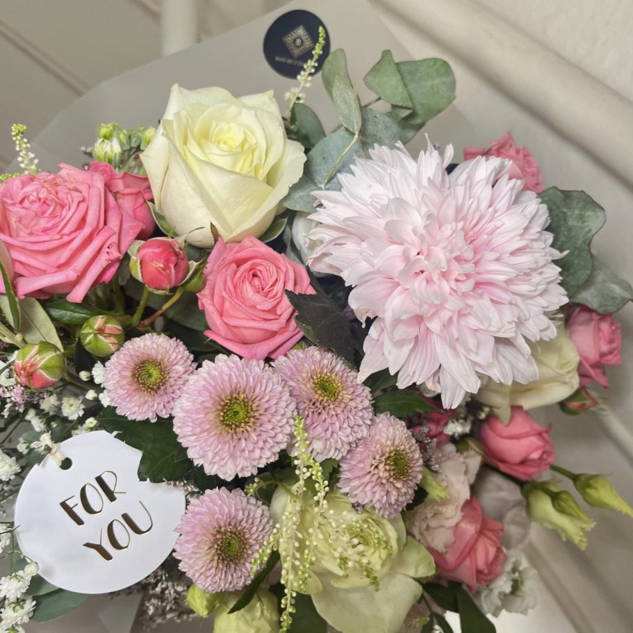 Ein üppiger Blumenstrauß mit Pfirsich- und weißen Rosen, Eukalyptus und zarten Akzenten.