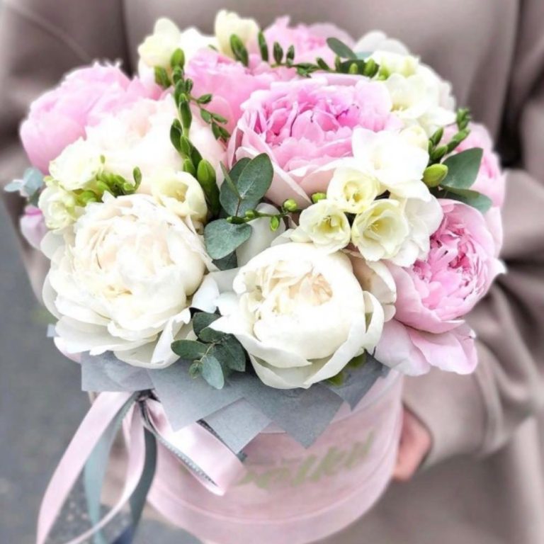 Ein üppiger Blumenstrauß mit Pfirsich- und weißen Rosen, Eukalyptus und zarten Akzenten.